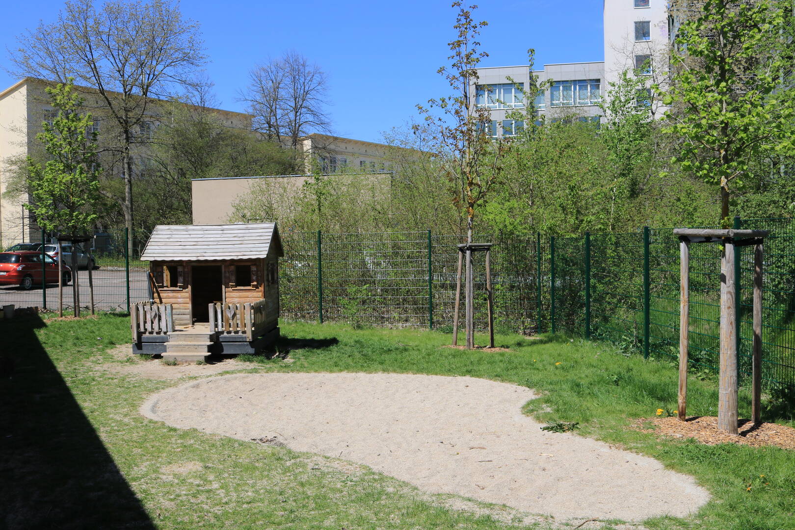 Natural garden area with a playhouse and sandpit