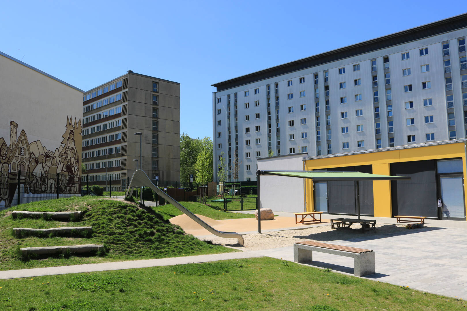 Garden area with a slide and a covered sandpit